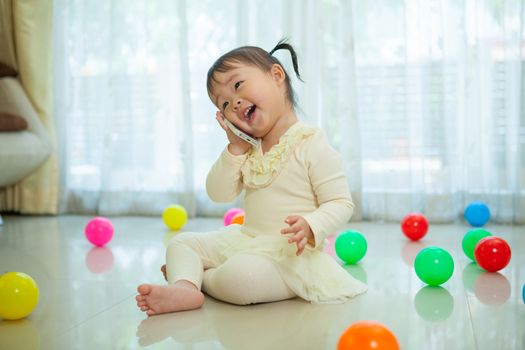 Portrait of pretty asian little girl talking on mobile phone