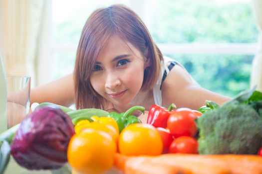 Happy asian woman cooking vegetables green salad in the kitchen