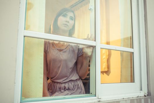 Beautiful young asian woman is sad at the window