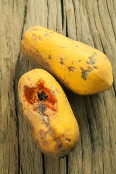 Closeup of moldy papaya fruit on wood background