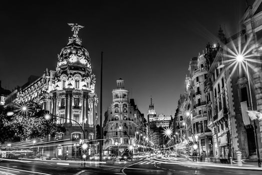 Rays of traffic lights on Gran via street, main shopping street in Madrid at night. Spain, Europe.