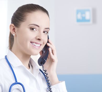 Young female doctor talking on the phone and smiling