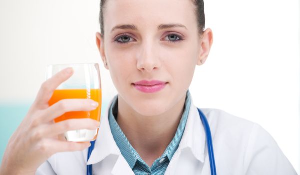 Female Nurse or Doctor holding a glass of orange juice.