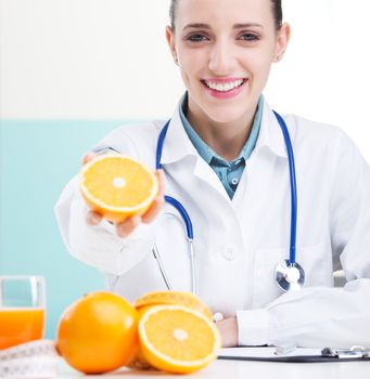 Happy female Nurse or Doctor holding an orange