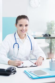Smiling woman doctor or pharmacist in office 