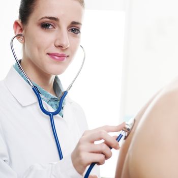 Female doctor listening man's back through stethoscope 
