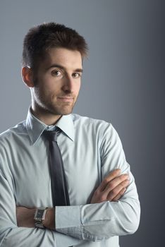 Confident businessman with arms crossed smiling at camera.