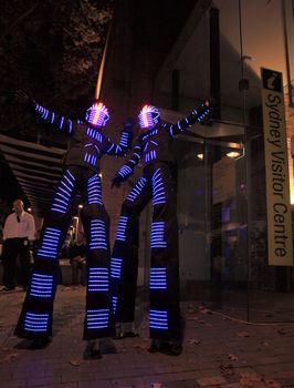 SYDNEY, AUSTRALIA - JUNE 6, 2014;  Illuminated stilt walkers wearing led light costumes at The Rocks district, for Vivid Sydney annual festival of light, music and ideas