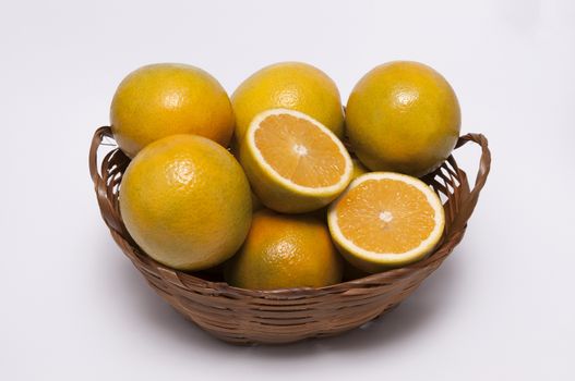 A Wicker Casket With Oranges on white background / Fruits