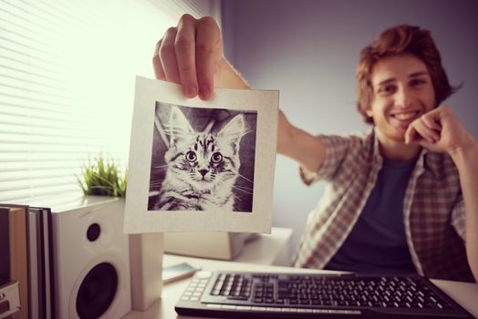 Young friendly guy video calling and showing a cat's picture.