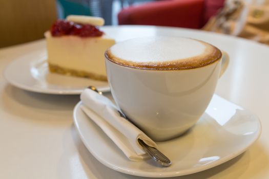 Coffee time with cakes in the background.