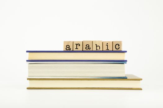 arabic word on wood stamps stack on books, language and education concept