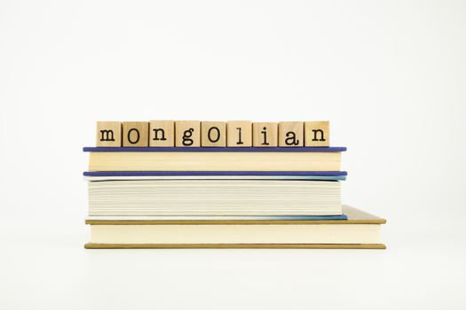 mongolian word on wood stamps stack on books, language and education concept