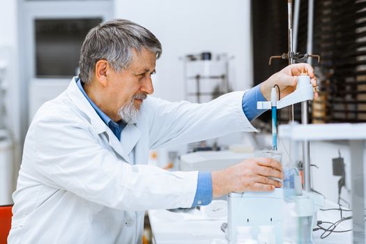 Senior male researcher carrying out scientific research in a lab (shallow DOF; color toned image)