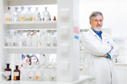 Senior male researcher carrying out scientific research in a lab (shallow DOF; color toned image)