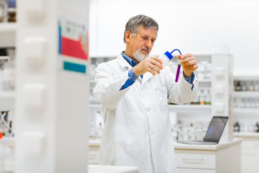 Senior male researcher carrying out scientific research in a lab (shallow DOF; color toned image)