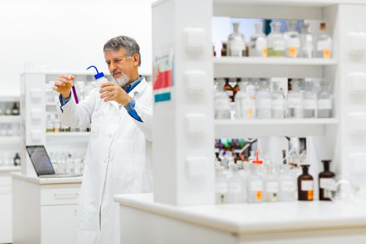 Senior male researcher carrying out scientific research in a lab (shallow DOF; color toned image)