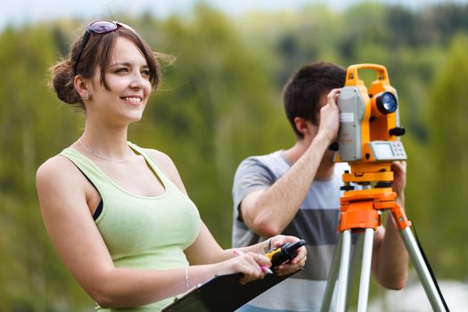 Two young land surveyors at work