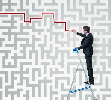 Elegant businessman on a ladder solving a maze with a brush.