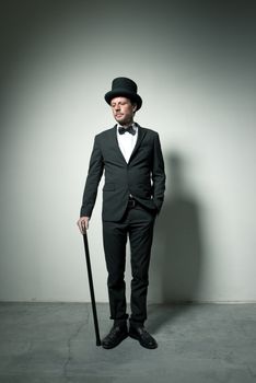 Classy gentleman with bowler hat and cane looking down