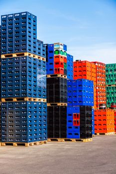Several stacks of colorful beverage bottle crates outdoors