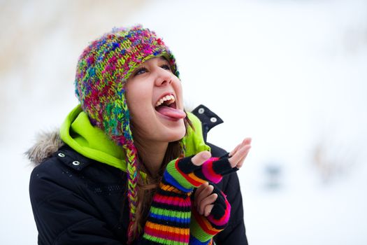 A teenage girl trying to catch falling snowflakes on her tongue.