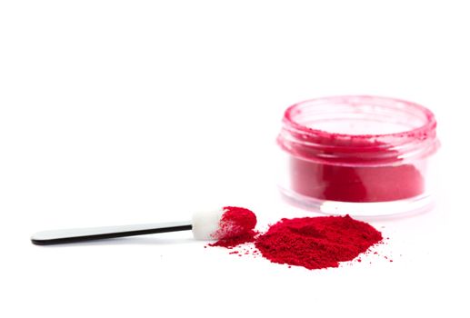 A pile of loose red powder with eyeshadow brush.  Shot on white background.