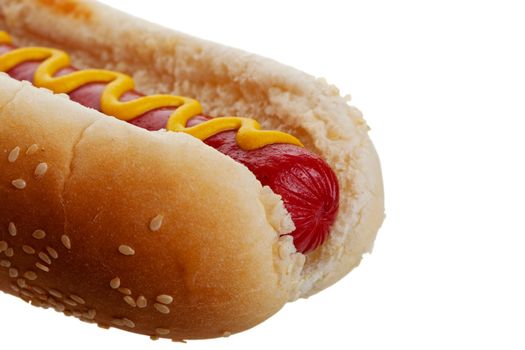 An old-fashioned hot dog with mustard, on a sesame seed bun.  Shot on white background.