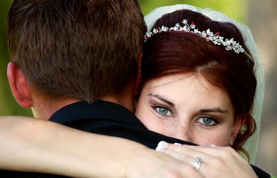 A beautiful bride, looking over the shoulder of her groom, on her wedding day.