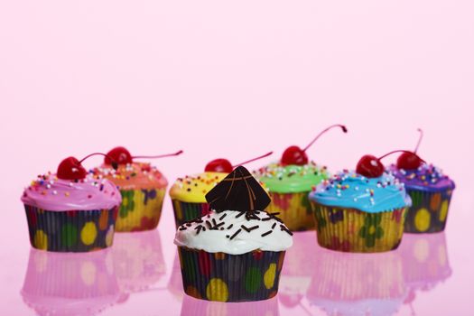 A variety of fancy cupcakes shot using pink gels.