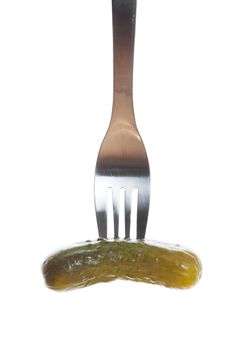 A dill pickle speared by a fork.  Shot on white background.