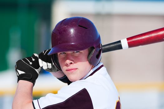 A teenage baseball player ready to bat.