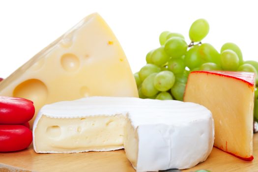 A variety of  cheeses served complimented with green grapes.   Shallow depth of field.