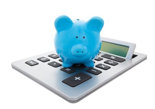 A blue piggy bank sitting on a large calculator.  Conceptual savings.  Isolated with clipping path.