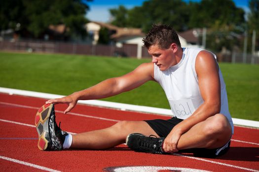 A young competitor does some warm up stretches before the big race.