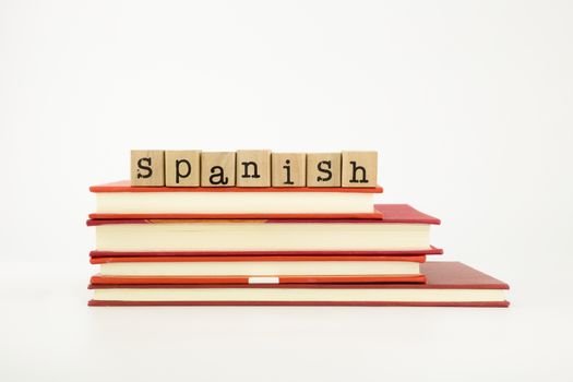 spanish word on wood stamps stack on books, language and academic concept