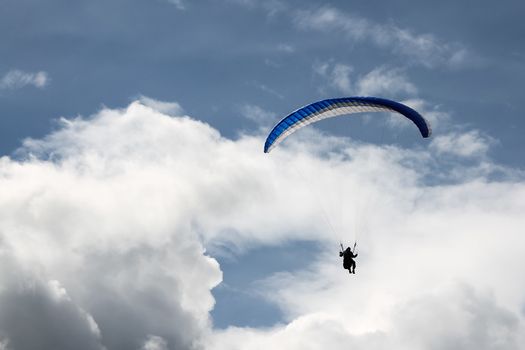 Paragliding against the blue and white skies