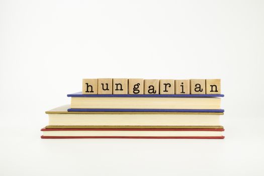 hungarian word on wood stamps stack on books, language and conversation concept