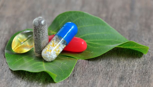 natural pills on green leaves
