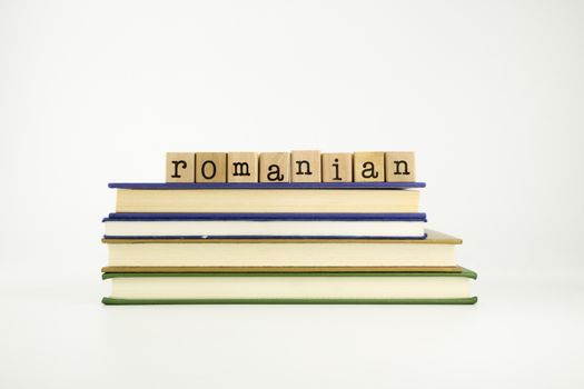 romanian word on wood stamps stack on books, language and conversation concept