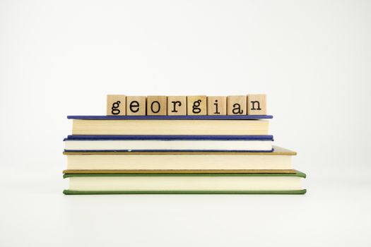 georgian word on wood stamps stack on books, language and conversation concept