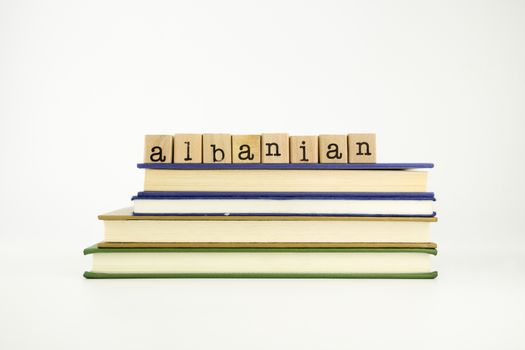 albanian word on wood stamps stack on books, language and conversation concept