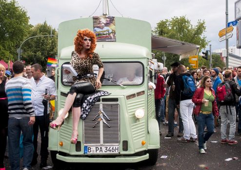 BERLIN, GERMANY - JUNE 21, 2014: Christopher Street Day.Crowd of people Participate in the parade celebrates gays, lesbians, bisexuals and transgenders.Prominent in the image a elaborately dressed transgender sitting on car.