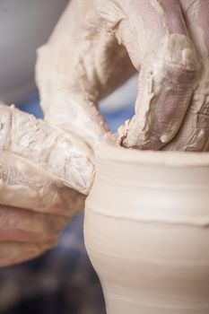 Hands of a potter, creating an earthen jar on the circle