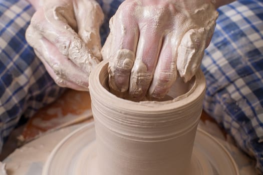 Hands of a potter, creating an earthen jar on the circle