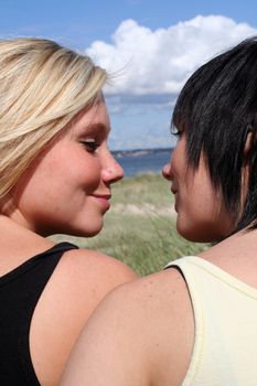 two Young women at the Beach flirting and kissing