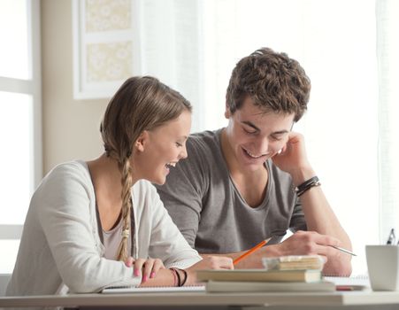Teen boy and girl sitting together and studying 