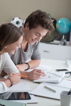 Teen boy and girl sitting together and studying 