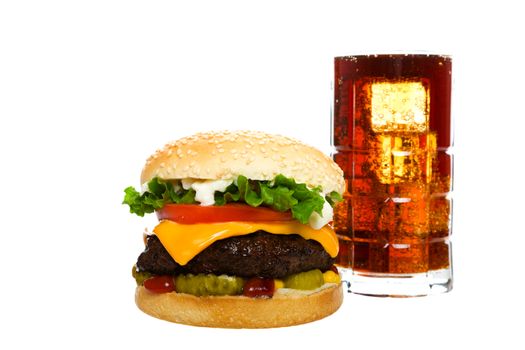 Juicy Angus beef burger topped with cheese, tomatoes & lettuce on a golden sesame seed bun along with a cool glass of cola on ice.  Shot on white background.