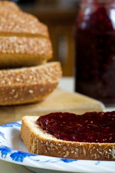 A thick layer of tangy raspberry jam, on whole wheat multi-grain bread.  Focus on bread.